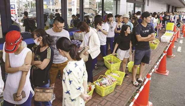 People line up to buy foods outside a store after an earthquake hit the area in Sapporo, Hokkaido, northern Japan.