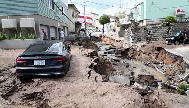 A car is seen stuck on a road damaged by an earthquake in Sapporo, Hokkaido prefecture.