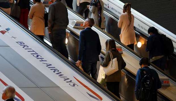 Commuters pass a British Airways advert on the tube at Canary Wharf station in London, Britain.