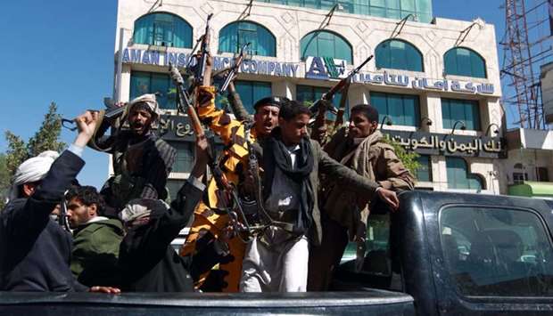 Houthi fighters shout slogans as they ride the back of a pick up in the Yemeni capital Sanaa. February 11, 2015 file picture