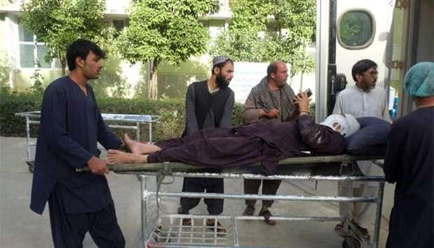A wounded Afghan passenger is transported to a hospital after a bus and truck collided in Kandahar province on Saturday.