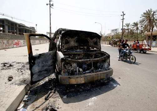 A burnt ambulance belonging to Iraqu2019s Popular Mobilisation Forces, during the protests, is seen in the street in Basra, yesterday.