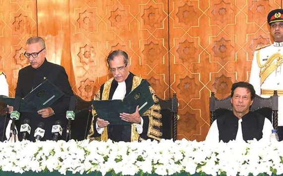 Pakistan Prime Minister Imran Khan, right, witnesses while Chief Justice of Pakistan Mian Saqib Nisar, centre, takes oath from newly President Arif Alvi, left, at the Aiwan-e-Sadr in Islamabad yesterday.