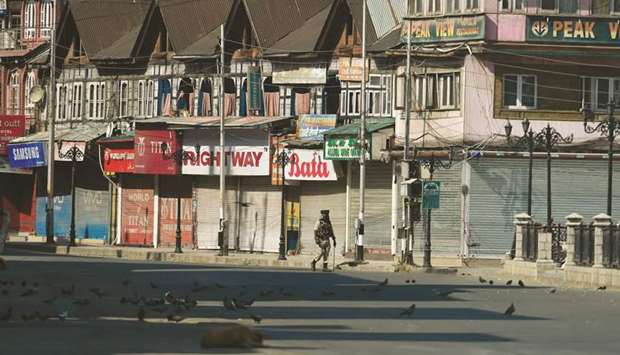 A paramilitary trooper patrols along an empty street during a strict curfew in Lal Chowk area of Srinagar.