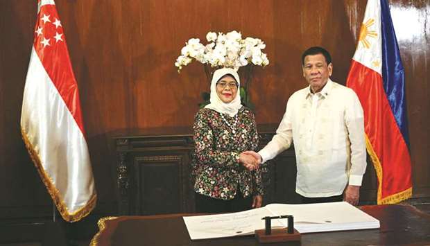 Singaporeu2019s President Halimah Yacob shakes hands with President Rodrigo Duterte after signing the guest book at Malacanang palace in Manila, yesterday.