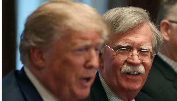 In this file photo taken on April 9, 2018 National Security Advisor John Bolton (R), listens to US President Donald Trump as he speaks about the FBI raid at lawyer Michael Cohen's office in Washington, DC