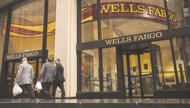 Pedestrians pass in front of a Wells Fargo & Co bank branch in New York. With rates for home loans sinking to their lowest levels since late 2016, the biggest mortgage lender in the US has boosted staffing for the business by about 10% this year and plans to keep hiring.