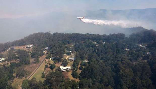 Queensland Fire and Emergency Services shows a firefighting 737 jet water bombing a fire at Binna Burra, some 100 kms (60 miles) south of Brisbane. Australia battled to contain around 160 bushfires in the east of the country