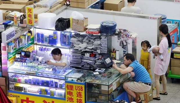 People are seen at stalls inside an electronics mall on Huaqiangbei Commercial Street, a marketplace for Chinese producers and international wholesale buyers, in Shenzhen, Guangdong Province, China