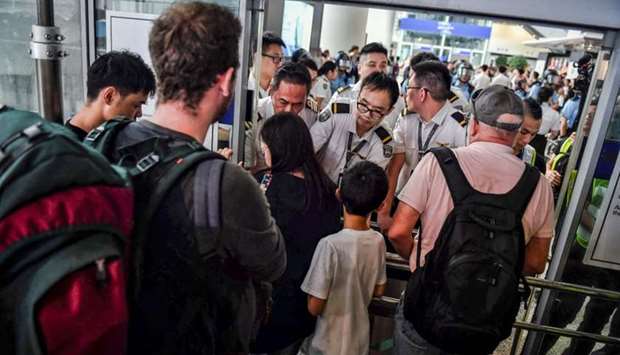 Officials assist arriving passengers near a blockade set up by protesters at Hong Kong International Airport. AFP