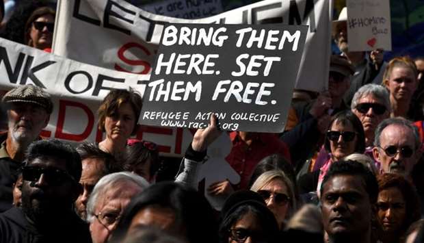 Protesters holds up placards in Melbourne, during a rally in support of a Tamil refugee family of four -- including two Australian-born toddlers -- who have been moved to the remote Australian detention centre on Christmas Island.