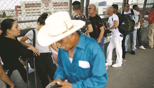 Cuban migrants queue while waiting for US Customs and Border Protection (CBP) agents, to cross into the United States to claim asylum, at the Santa Fe border crossing bridge in Ciudad Juarez, Mexico.