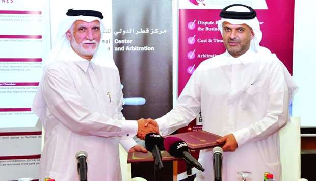 Dr Sheikh Thani and Dr al-Emadi shaking hands after signing the agreement