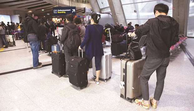 Passengers stand with their luggage as they queue at a boarding gate inside Charles de Gaulle airport in France. As the Chicago Convention turns 75, there are challenges ahead for the global aviation industry, especially in relation to u2018Open Skiesu2019.