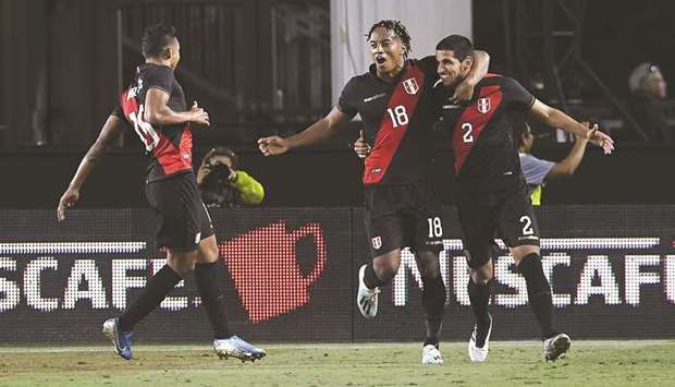 Peruu2019s Luis Abram (right) celebrates with teammates Christofer Gonzales (left) and Andre Carrillo after scoring against Brazil in a friendly in Los Angeles. (AFP)