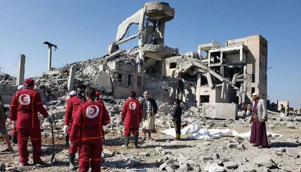 Red Crescent medics stand at the site of Saudi-led air strikes on a Houthi detention centre in Dhamar