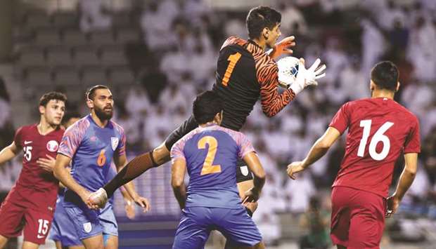 Indiau2019s goalkeeper Gurpreet Singh Sandhu (C, top) leaps to pouch the ball during their match against Qatar at the Jassim Bin Hamad Stadium in Doha on Tuesday.
