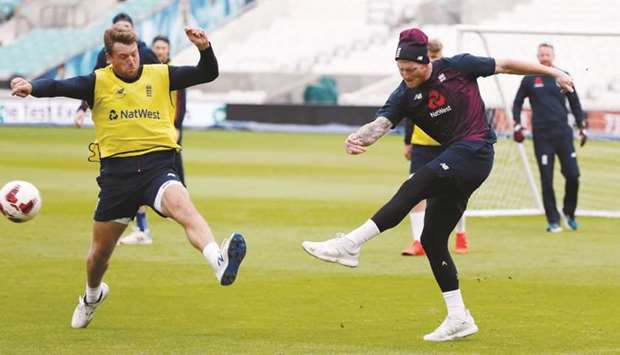 Englandu2019s Jos Buttler (L) and Ben Stokes play a game of football during a training session at The Oval in London yesterday.