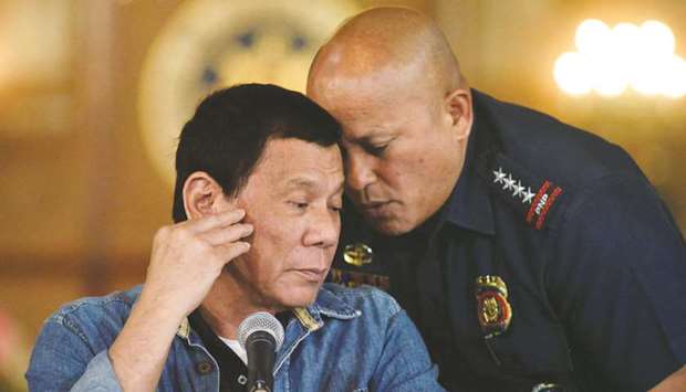 File photo shows Philippine National Police chief General Ronald dela Rosa whispering to President Rodrigo Duterte during the announcement of the disbandment of police operations against illegal drugs at the Malacanang palace in Manila.