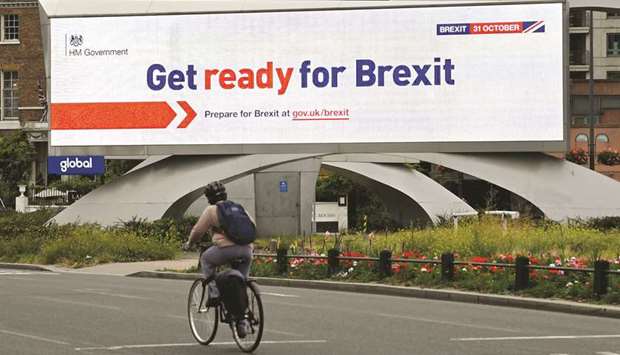 A cyclist rides past an electronic billboard displaying a government Brexit information awareness campaign advertisement in London yesterday.