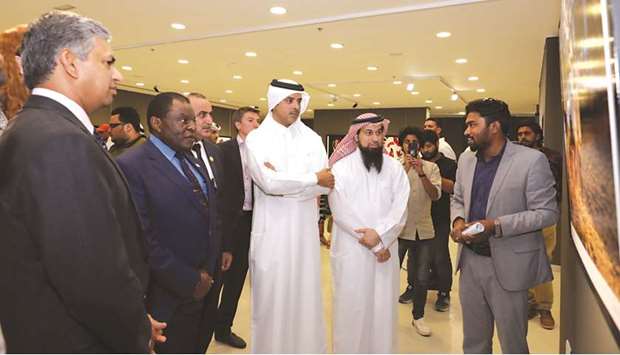 Artists brief Saif Saeed al-Dosari and other attendees about their works.