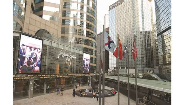This general view shows the flag (centre) of the Hong Kong Stock Exchange flying next to the Chinese national flag (2nd left) and the Hong Kong SAR flag, outside the exchange offices in the Central district of Hong Kong. The plan by HKEX to take over London Stock Exchange is running into multiple obstacles a day after the surprise bid was launched, with the UK bourse leaning towards rejecting the offer in its current form.