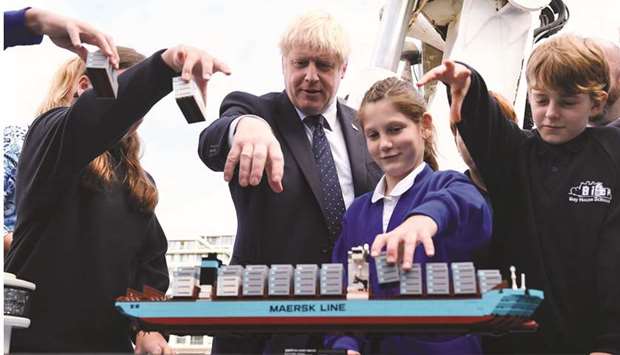 Prime Minister Boris Johnson takes part in an activity with school children as he visits the NLV Pharos, a lighthouse tender moored on the river Thames to mark London International Shipping Week in London yesterday.