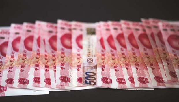 A Hong Kong five-hundred dollars banknote (centre), is arranged for a photograph with Chinese one-hundred yuan banknotes in Hong Kong. The onshore yuan finished domestic trading up 0.38% at 7.0082 per US dollar, marking its firmest close since August 23.