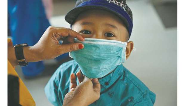 A young boy wears a mask to protect against the air pollution brought from regional fires at Sultan Syarif Kasim II airport in Pekanbaru, Riau province, Indonesia.
