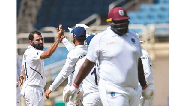 Mohamed Shami (left) of India celebrates the dismissal of Rahkeem Cornwall (right) of West Indies on third day of the second Test in Kingston, Jamaica, yesterday. (AFP)