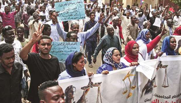 People chant slogans as they march in Khartoum yesterday with banners and signs calling for the appointment of a new permanent chief of judiciary and prosecutor general.