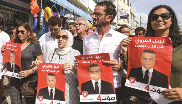 Najiba Karoui (second left), mother of Tunisiau2019s jailed presidential candidate Nabil Karoui, stands alongside his sister Rim (left) and others holding up his election poster while campaigning for him in the northern city of Bizerte.