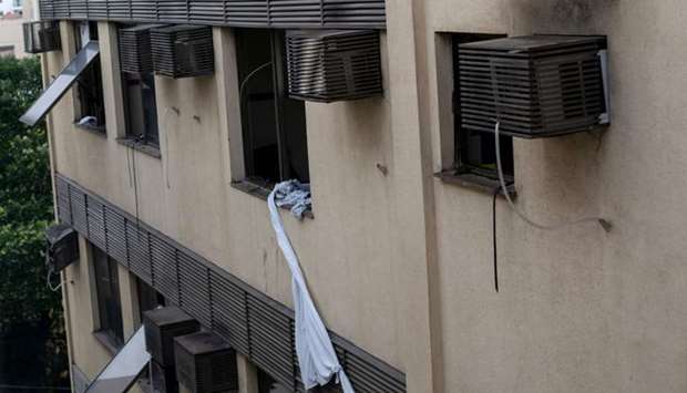 Sheets tied together hang from a window of the Badim private Hospital following a fire at the Tijuca neighborhood, Rio de Janeiro, Brazil