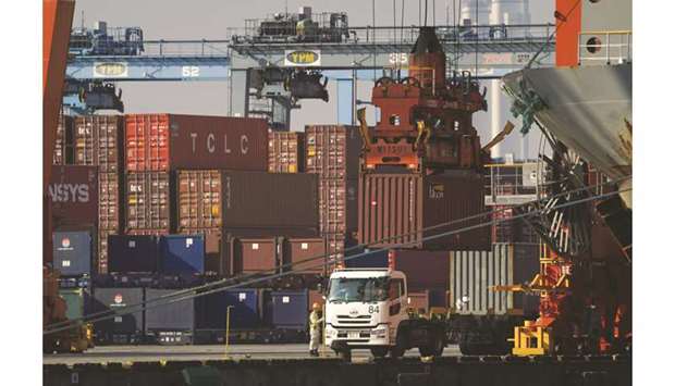 A worker stands next to a truck as a gantry crane moves a container at a shipping terminal in Yokohama. Japanese exports in August are forecast to have slumped 10.9% from a year earlier, which would be the biggest shrinkage since 14% in July 2016 and a far sharper one than Julyu2019s 1.5% drop.