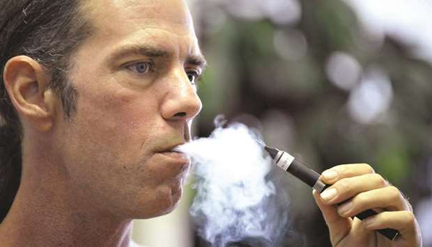 Tyler Bush, manager of The Vapor Bar in Grapevine, Texas, puffs on an electronic cigarette.