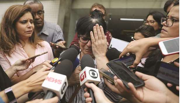 Tania Texeira, daughter of victim Alice Texeira, cries as she talks with journalists at the Institute of Forensic Science after a fire hit the Badim Hospital in Rio de Janeiro, Brazil.
