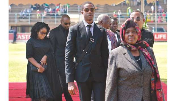 The children of Zimbabweu2019s former president, the late Robert Mugabe, Robert Junior (centre), Chatunga (right-partially obscured) and Bona (left) arrive at Rufaro stadium, yesterday where the body of Mugabe lays in state for a second day.