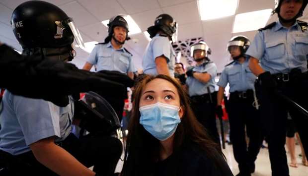 A protester is detained by the police officers at Amoy Plaza shopping mall in Kowloon Bay, Hong Kong, China