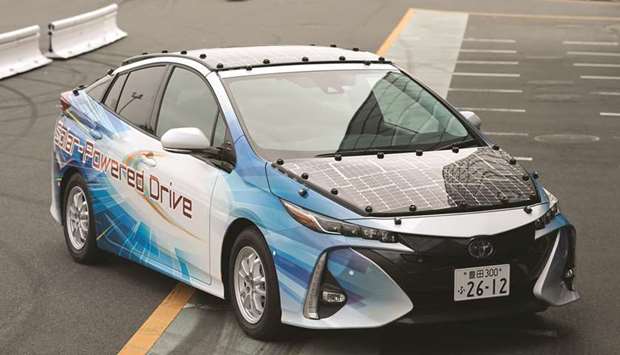 A Toyota Prius PHV plug-in hybrid vehicle equipped with a solar charging system sits parked on a test course in Tokyo on Tuesday. Put together the best solar panels money can buy, super-efficient batteries and decades of car-making know-how and, theoretically, a vehicle might run forever.