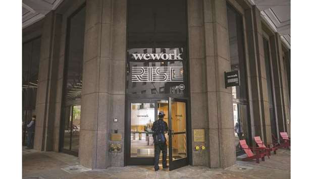 A man enters a WeWork office facility in New York City. The company is considering a valuation of potentially less than $20bn after being previously valued on the private market for as much as $47bn.