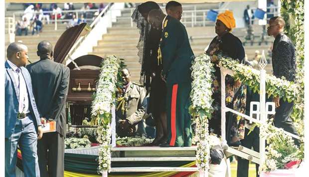 Zimbabweu2019s former first lady Grace Mugabe (centre) says a final farewell at the casket of late president Robert Mugabe.