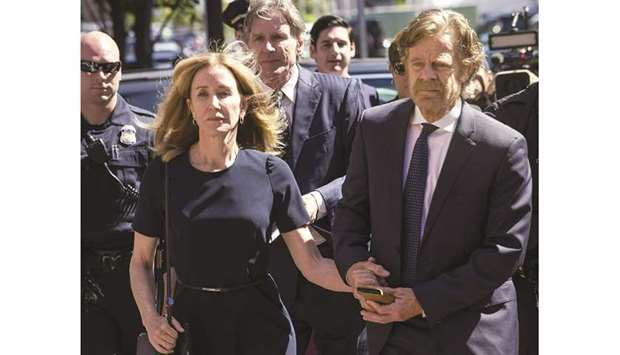 Actress Felicity Huffman and husband William H Macy walk outside the John Joseph Moakley United States Courthouse in Boston on Friday.