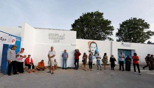 People wait to cast their vote outside a polling station during presidential election in Tunis, Tunisia
