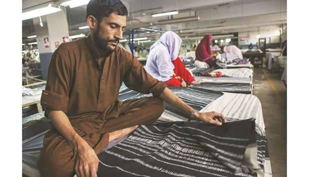 Workers inspect pieces of fabric ahead of stitching at DL Nash, a textile manufacturer in Karachi. Pakistan Prime Minister Imran Khan has chaired a meeting of his economic team where he was told that the governmentu2019s economic policies were coming to fruition due to considerable reduction in trade deficit, increase in exports and increased tax collection.