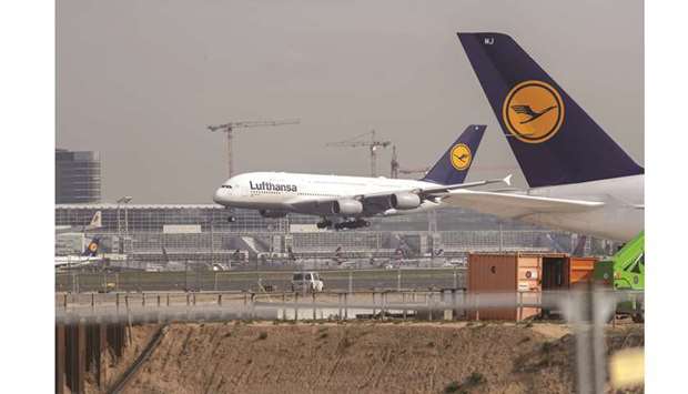 A passenger aircraft operated by Deutsche Lufthansa lands beyond the construction site of Frankfurt airportu2019s new Terminal 3 in Frankfurt (file). A proposed price floor for airline tickets would be easier for Lufthansa to absorb than for the low cost carriers whose business strategy centres on having aircraft more than 95% full.