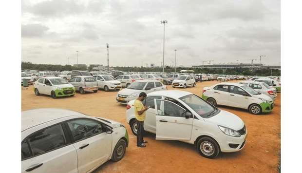 A cab driver checks his mobile phone after parking at a designated area near Rajiv Gandhi International Airport in Hyderabad. When Indiau2019s Finance Minister Nirmala Sitharaman on September 10 claimed millennialsu2019 preference for ride-hailing apps was contributing to a painful slump in car sales, it sparked a online backlash from furious youngsters.