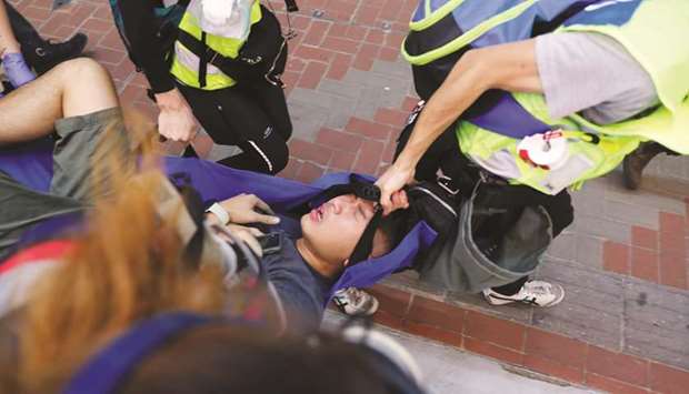 An anti-government protester is carried away near an entrance of Causeway Bay station in Hong Kong.