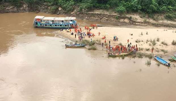 Members of National Disaster Response Force (NDRF) along with other government officials search for missing people, after a tour boat capsized in Godavari river