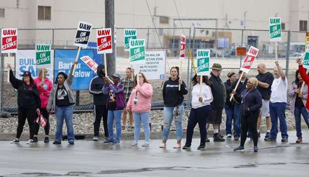 United Auto Workers (UAW) members picket at a gate at the General Motors Flint Assembly Plant after the UAW declared a national strike against GM at midnight