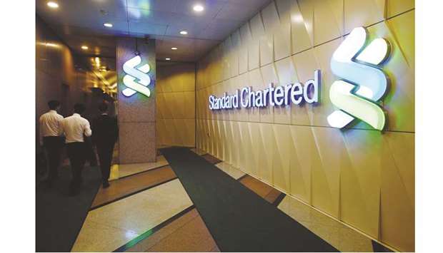 People walk inside the main branch of Standard Chartered in Hong Kong. StanChart, fined billions of dollars since 2012 for regulatory violations, has discovered that it cannot explain how some of its wealthiest clients acquired their fortunes and is reviewing thousands of customer accounts at its private bank.